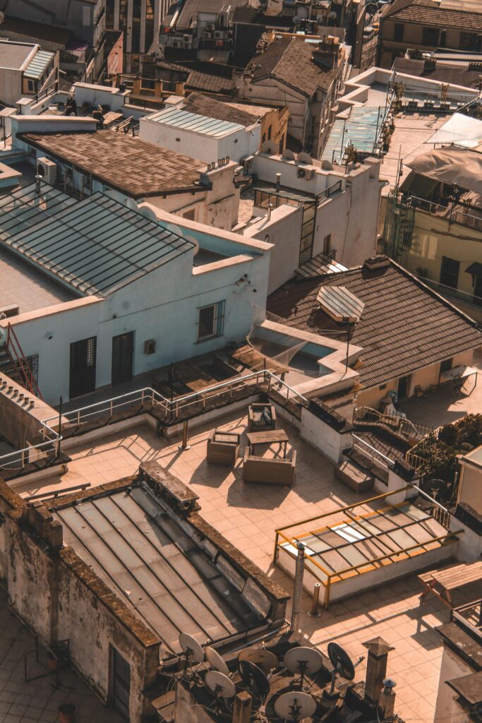 Aerial view highlighting diverse urban rooftops with warm tones and shadows.